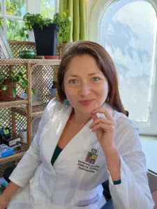 Fotografía de Kattyna Godoy, Psiconeuroinmunóloga Clínica y Nutricionista Integrativa, sonriendo con fondo blanco.